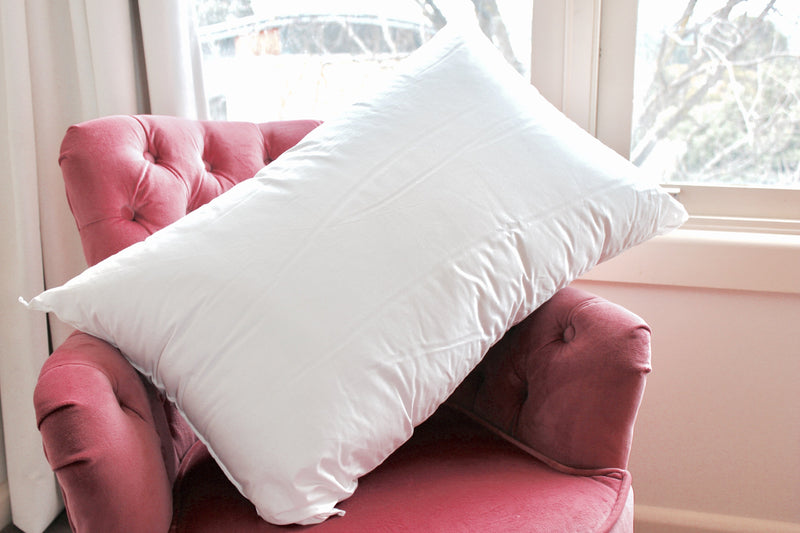 Kids pillow resting on a pink velvet chair