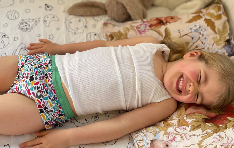 girl smile in bed wearing night training mosaic pattern