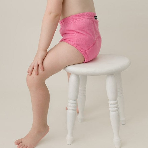 Toddler wear pink training pants sit on the chair